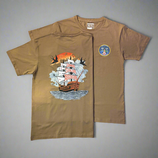 Brown t-shirt with a graphic design of a ship and text on a flat surface.
